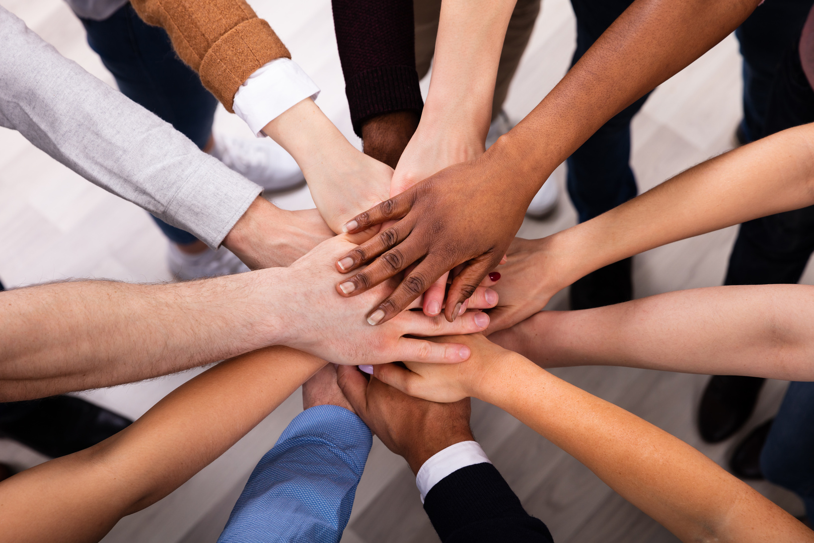 A diverse group of hands joined together in community